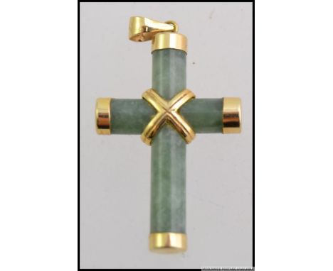 A 14ct / 535 gold and jade crucifix necklace pendant. The hoop being hallmarked, jade cross with gold banding. Total weight 3