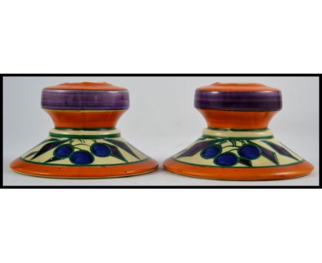 A pair of Art Deco Clarice Cliff Fantasque candlesticks marked to the base with additional markings for Lawleys Norfolk Potte