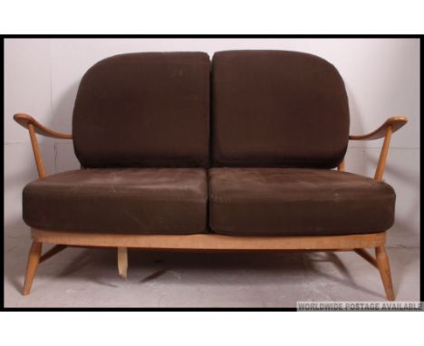 A 1970's retro Golden Dawn Ercol beech and elm Windsor pattern 2 seat sofa settee couch. Raised on stub turned legs with stre