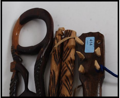 A collection of African carvings to include a musical instrument in a skin case, a small mandolin, a walking stick and other 