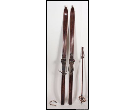 A pair of vintage / retro wooden mid century ski's together with a bamboo walking pole.