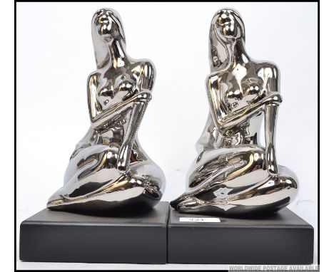 A pair of 20th century ceramic chrome style female figural bookend, mounted on plinth bases