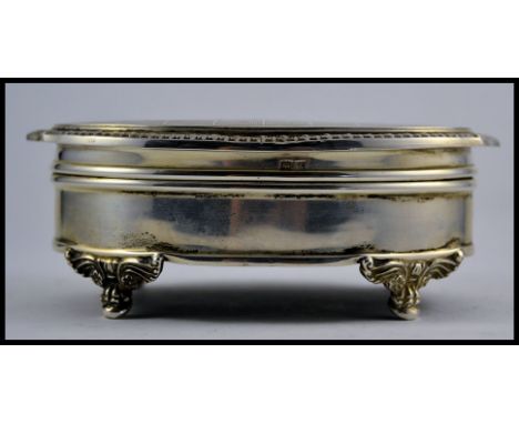 A silver hallmarked ladies jewellery trinket box raised on decorative feet having hinged top and lined interior. Birmingham h