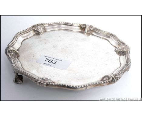 A Victorian silver hallmarked card tray being raised on claw and ball feet ( two missing ) by Daniel & John Wellby with Londo