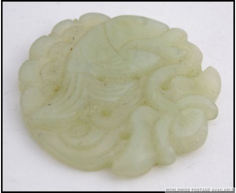 A Chinese Jade roundel carving of a fish  in the sea ( see illustrations ) W6cm 