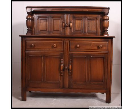An Ercol Golden Dawn beech and elm wood court cupboard sideboard. Raised on stile legs with cupboards and drawers with court 