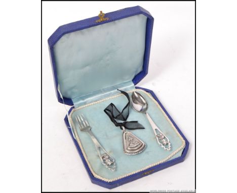 A silver continental cased Christening set consisting of a babies rattle, spoon and fork with marks for Porto