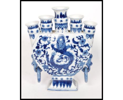 A Chinese blue and white five planter moon vase bearing dragons and tress to each side. Measures 29cm tall.