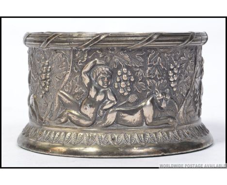 A 19th century silver plated wine coaster moulded in relief with grape and vine with cherubs intertwined. W12cm 