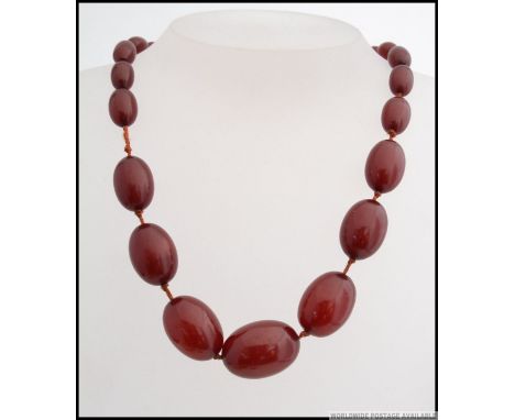 A stunning vintage red amber ladies necklace. The knotted string with graduating amber droplets having barrel clasp