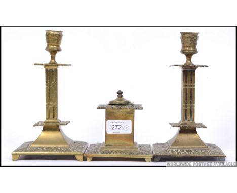 A pair of Victorian brass candlesticks having single sconces together with a matching inkwell.