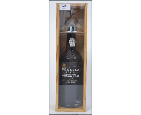 A cased bottle of Fonseca Porto Guimaraeans Vintage 1986 Port. Bottled in 1988 along with a white metal funnel. H36cm 