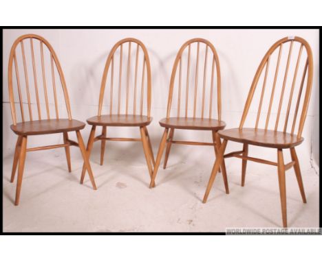 A set of 4 Ercol Quaker pattern beech and elm wood dining chairs. Each with panel seats, arched back rests on turned legs. Ma