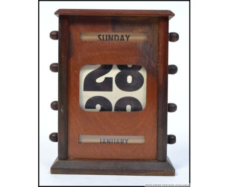 A vintage early 20th century mahogany cased desk top calendar. The side with swivel crown and paper date / day insets