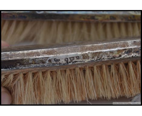 A silver hallmarked gentlemans clothes brush set being hallmarked together with the hand mirror. Hallmarks for Birmingham 191