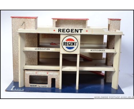 An original vintage wooden made childs toy garage with advertising slogans for Regent. H42 x W68 x W39cm 