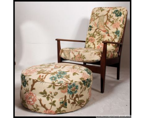 A vintage mid century Danish influence teak open frame lounge armchair together with  the ottoman footstool in a chintz fabri