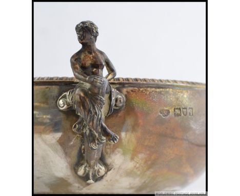 A silver hallmarked  twin handled rose bowl having stunning twin handles of a maiden and a faun playing a musical instrument.