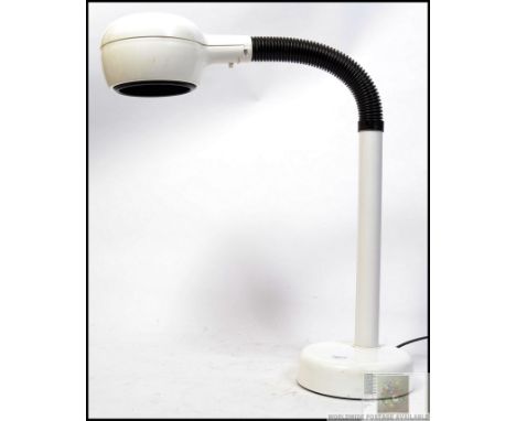 A retro desk lamp, finished in white, enameled lamp shade and base, joined by a black, rubber-sleeved, flexible metal goosene