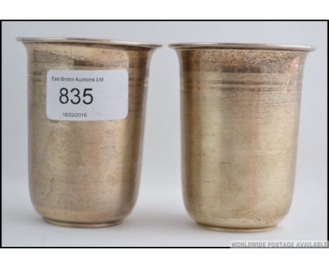 2 silver ( tested ) 20th century stirrup cups being engine turned having illegible marks to the base. Total weight 74.7g. H8c