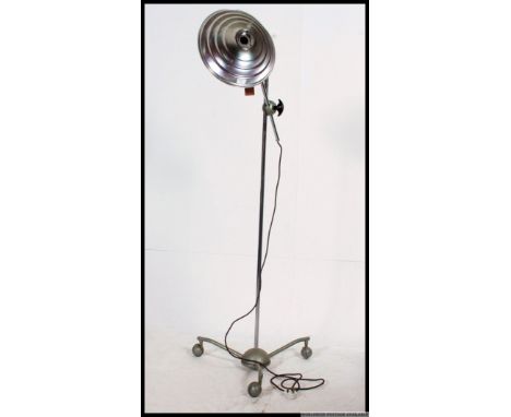 A vintage mid century floor standing adjustable heat lamp by Hanovia, having a metal tubular adjustable hight frame raised on