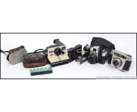 A collection of vintage and retro cameras to include Polaroid, 35mm, a vintage bakelite  Coronet Vogue etc