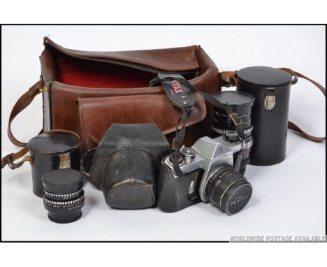 A vintage Pentax Ashai 35mm camera along with spare lenses all cased along with a camera bag