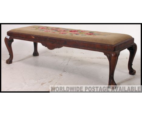 A believed 19th century walnut and tapestry upholstered Queen Anne style long foot stool being raised on cabriole legs with c