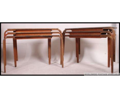 A stack of vintage 20th century stacking school desks. The legs of bentwood form having cream vinyl covered tops to each.  H6