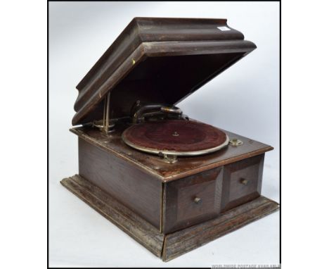 An early 20th century possibly His Masters Voice oak cased wind up gramophone having a hinged caddy top, opening front sound 
