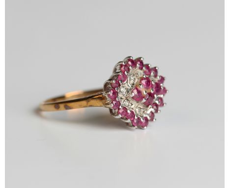 A 9ct gold ruby and diamond cluster ring, mounted with the four principal circular cut rubies within a surround of eight circ