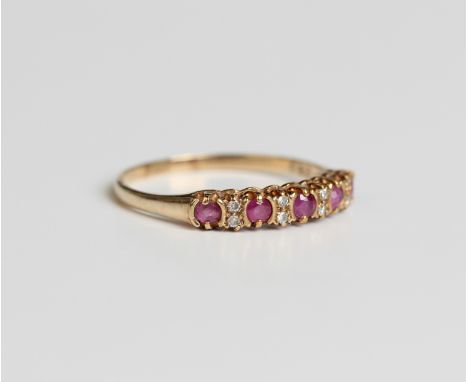 A 9ct gold ruby and diamond half hoop ring, mounted with five circular cut rubies and four pairs of small circular cut diamon