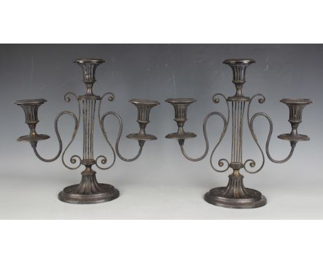 A pair of early 20th century plated lyre three-light candelabra, each oval reeded sconce with detachable nozzle above scroll 