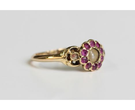 A gold, ruby and seed pearl cluster ring, mounted with the seed pearl within a surround of ten cushion cut rubies, weight 1.9