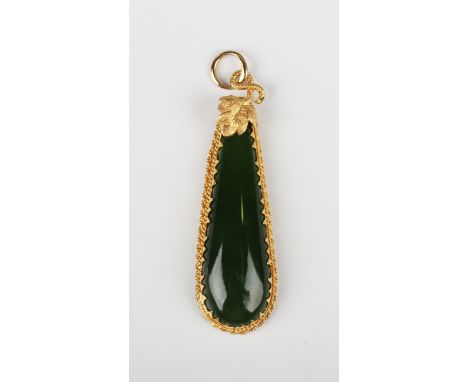 A gold and jade pendant of elongated drop form with a leaf and scrolling stem surmount, weight 4.3g, length 4.5cm.Buyer’s Pre
