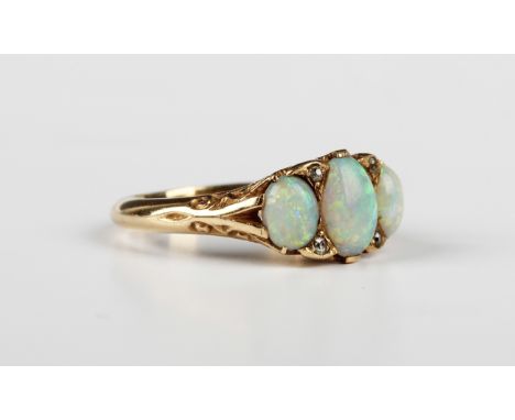 An opal and diamond ring, circa 1900, mounted with three graduated oval opals and two pairs of cushion cut diamonds at interv