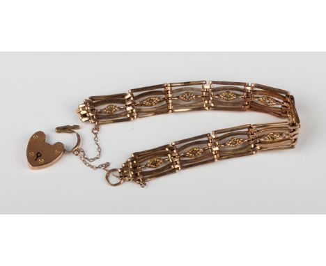 A gold bar and decorated link gate bracelet, detailed '9ct', on a gold heart shaped padlock clasp, detailed '9ct', weight 20.
