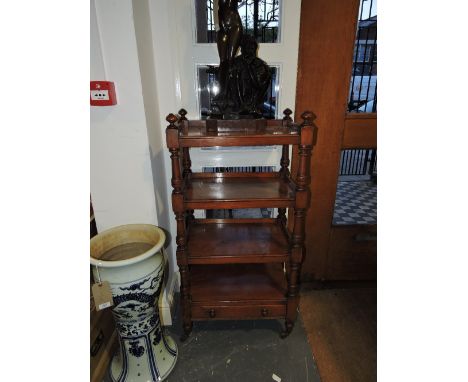 A Victorian mahogany four-tier étagère, with quarter galleries on square and turned supports, with an apron drawer on brown c