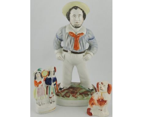 A 19th century Staffordshire model of a Matlow, straw hat and orange scarf standing on a naturalistic base, together with two