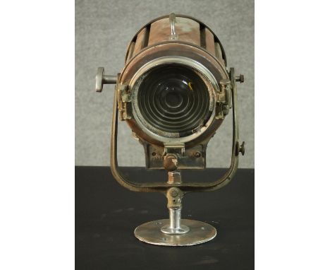 A vintage Mole-Richardson theatre spotlight and hinged wall bracket. Relief makers mark. H.20 Dia.22cm. 