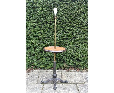 A vintage brass standard lamp with central tier on wrought iron lion's paw quadruped base. H.131 W.38cm 