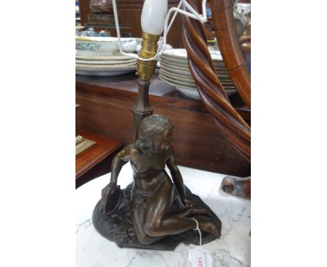 A 1930'S BRONZED SPELTER TABLE LAMP in the form of a nude young woman holding a tambourine (large chip to front)