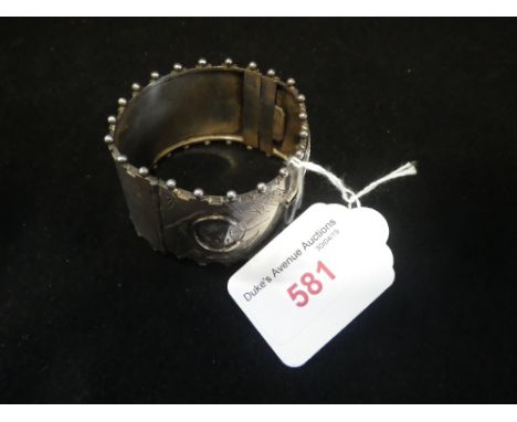 AN UNMARKED WHITE METAL HINGED BANGLE, with concealed clasp