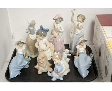 Eight Nao figures of children, including four modelled with birds, one with a butterfly, and three modelled with teddy bears,