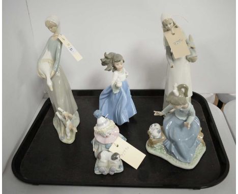 Lladro figure of a child clown, modelled with puppy, 12cms high; along with a Lladro figure of a lady, two Nao figures of gir