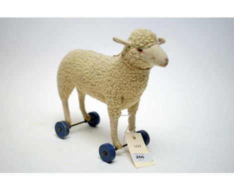 An early Steiff lamb pull toy, poised over four wheels, with Steiff button to ear. 