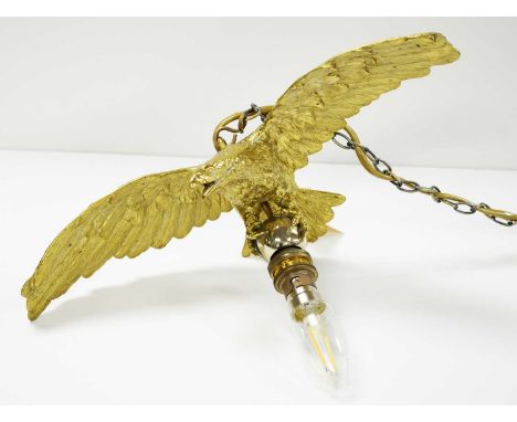 Gilt metal light pendant, formed as an eagle modelled upon a silvered ball, wingspan 35cms wide.