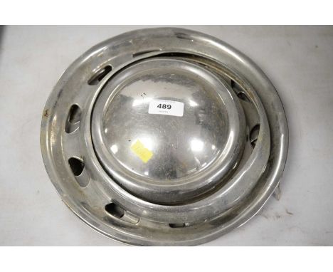 Three 1960's Mini hub caps; along with a light bezel (4)