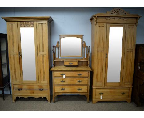 An early 20th Century walnut three-piece bedroom suite, comprising; a single door wardrobe, the projecting pierced cornice ab