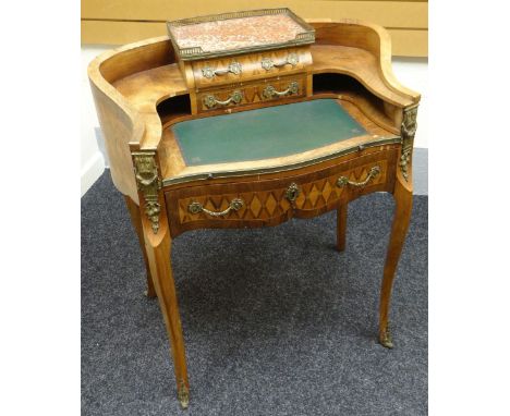 A bonheur du jour in parquetry and ormolu decorated kingwood, shaped with concave sides, furnished with leather sliding work-